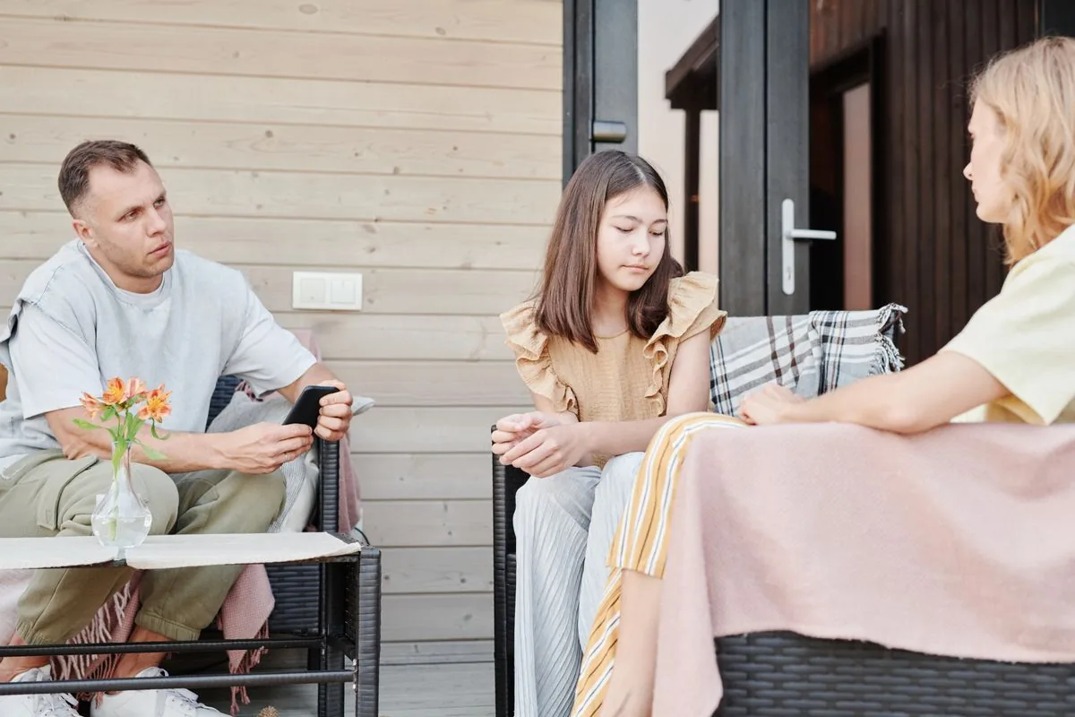 Ba người trong gia đình nói chuyện ngoài sân