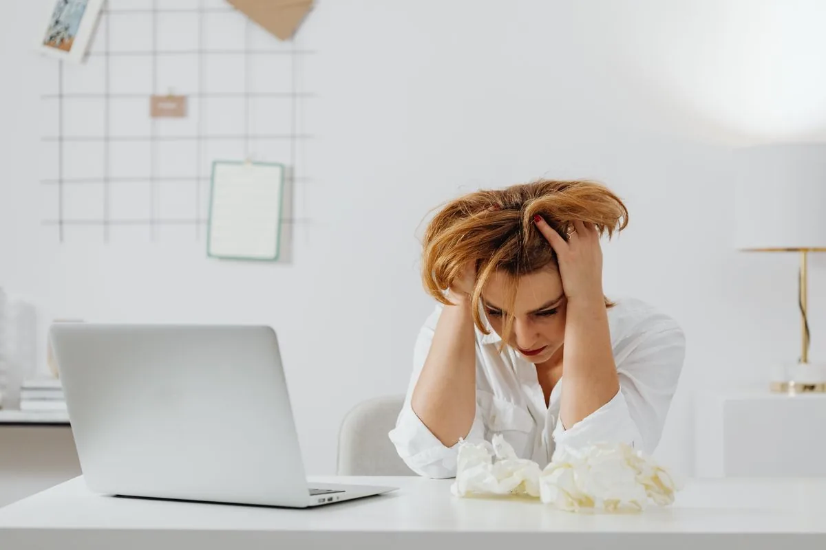 Một người ngồi trước máy tính với vẻ mệt mỏi