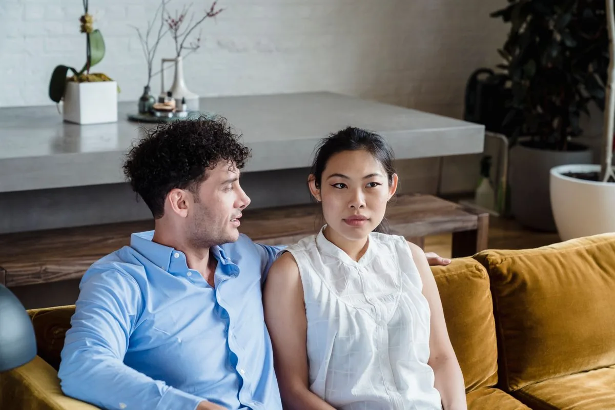 Hai người ngồi cạnh nhau trên ghế sofa trong nhà